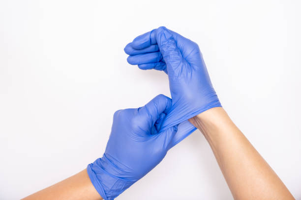 Doctor putting on blue powder free nitrile gloves, review 